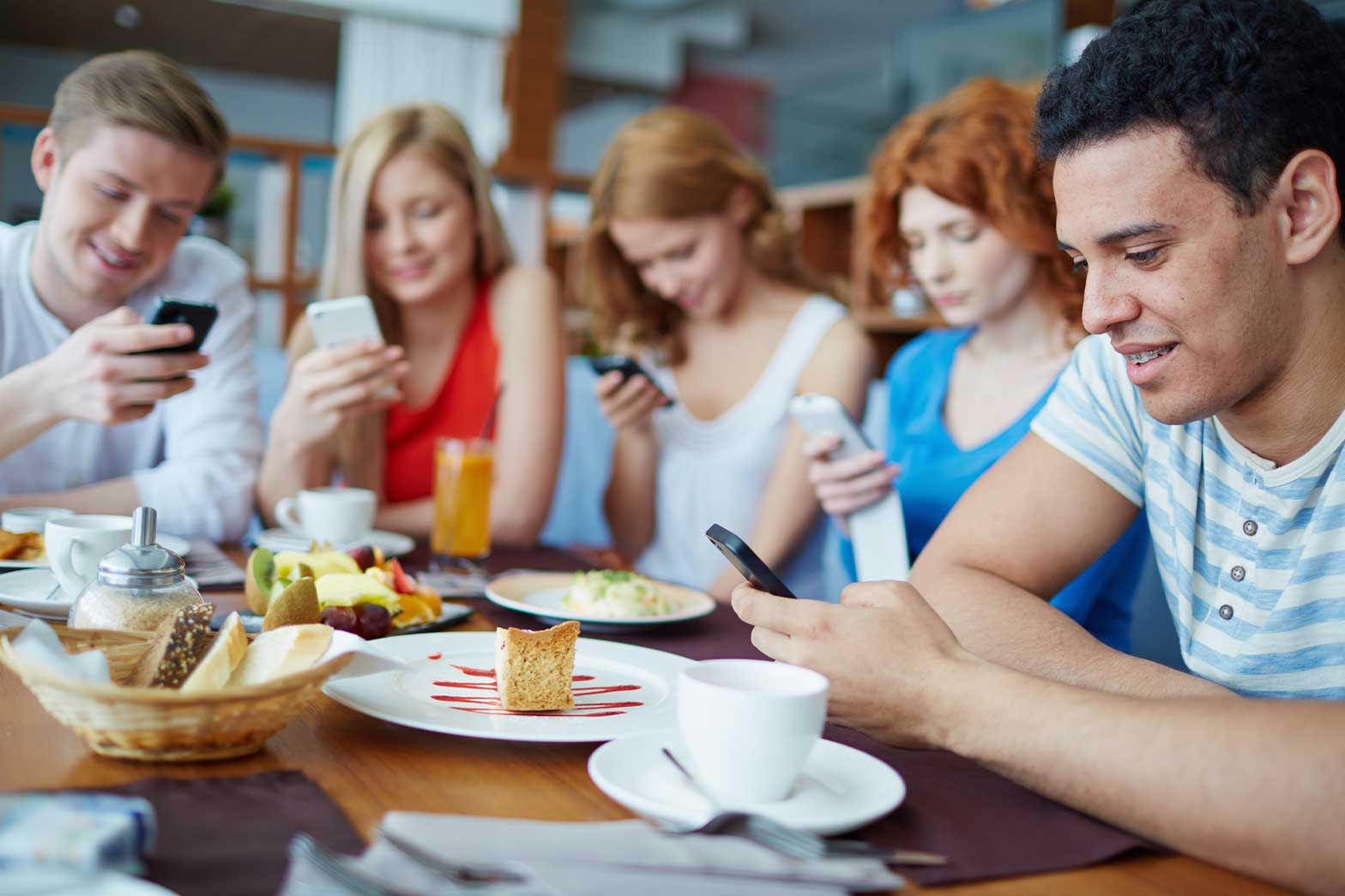 A group of young people focusing their attention on their mobile phones