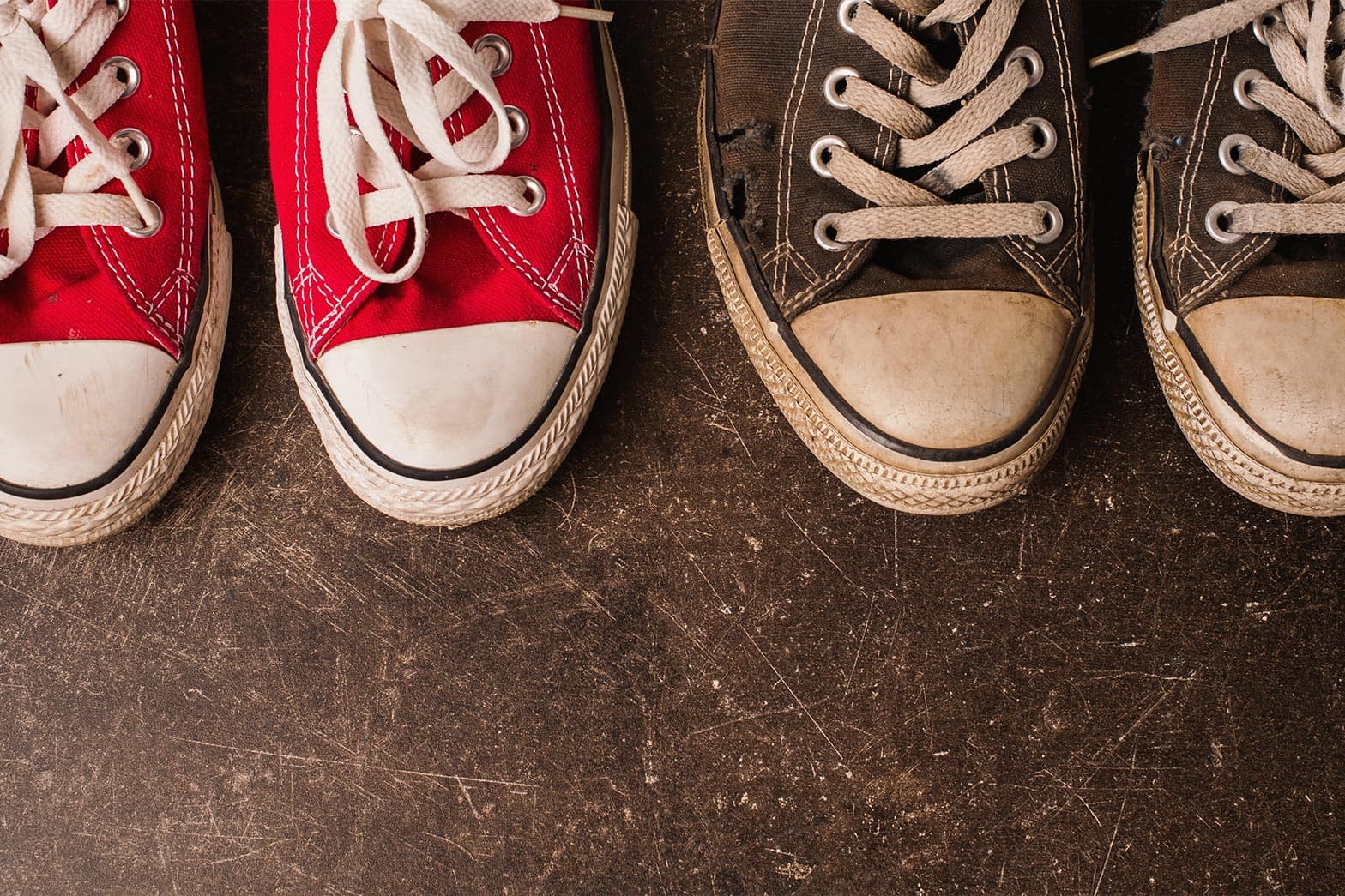 A photo of a clean pair of shoes next to a dirty pair of shoes