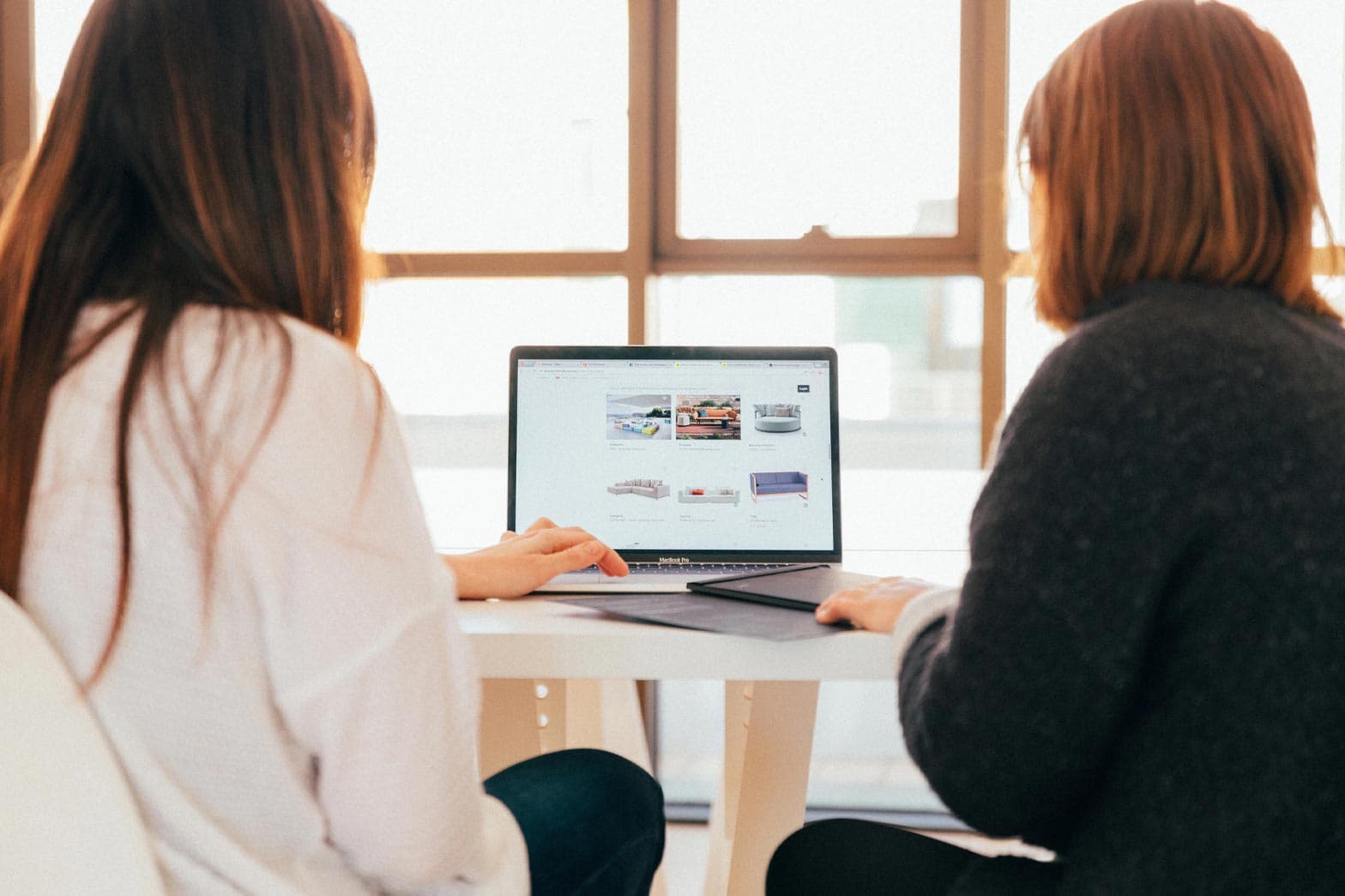 Two women reviewing their online business presence on a laptop