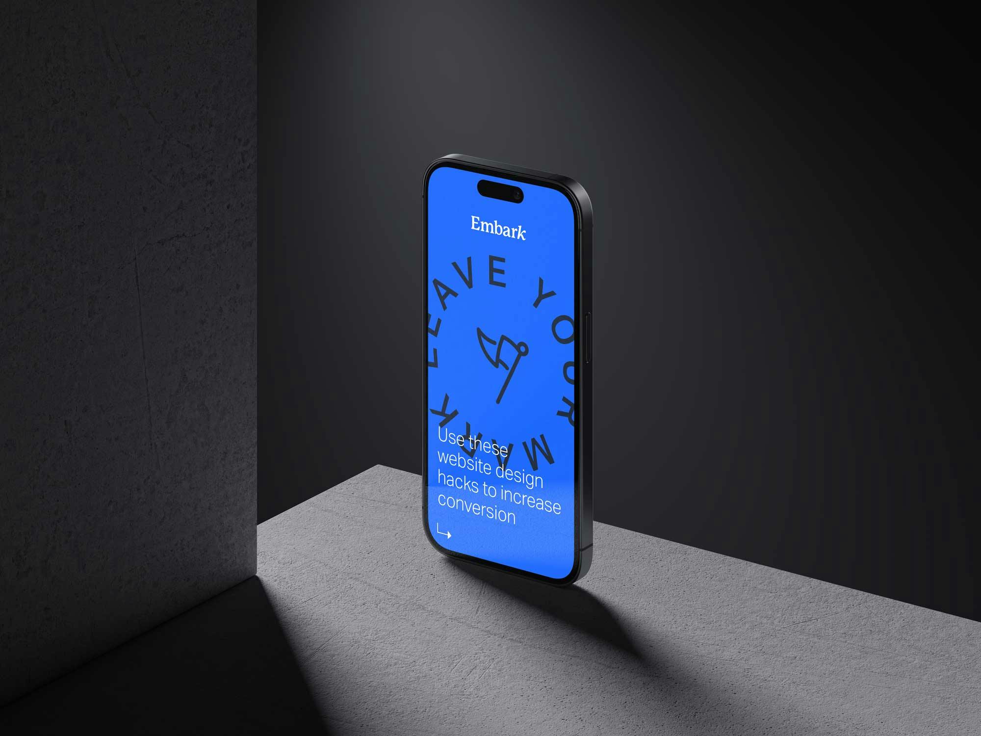 an iPhone 14 sitting in a dark concrete room with a blue screen and the Embark logo on it with the words 'Use these website design hacks to increase conversion