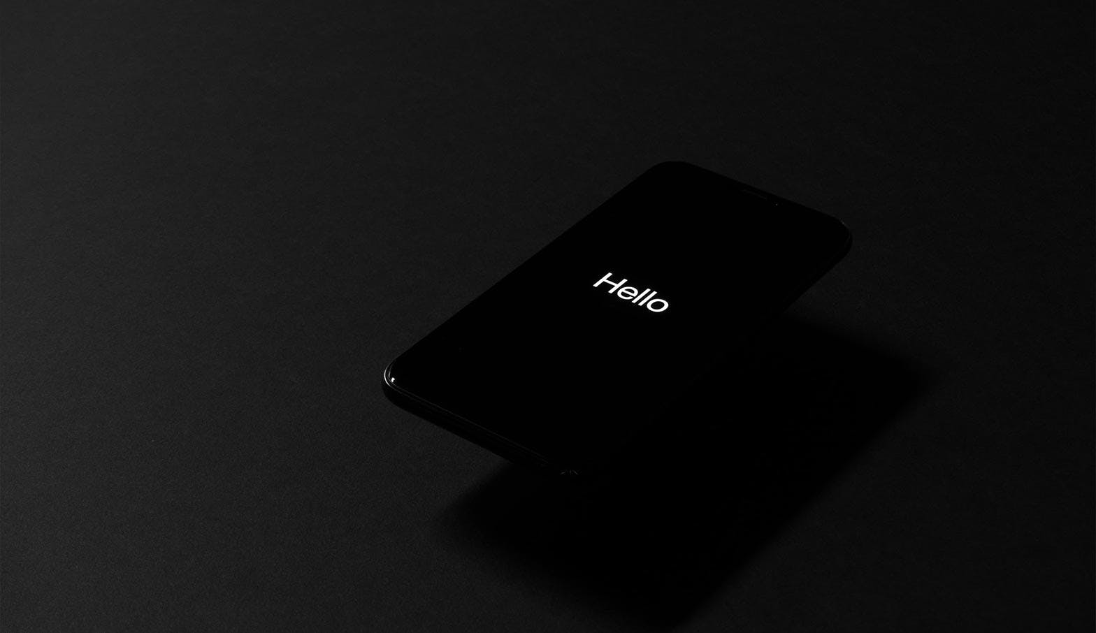A mobile phone with the word 'Hello' on screen