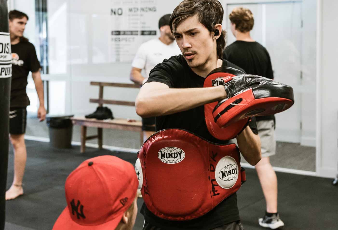 Young man practicing boxing with red gloves