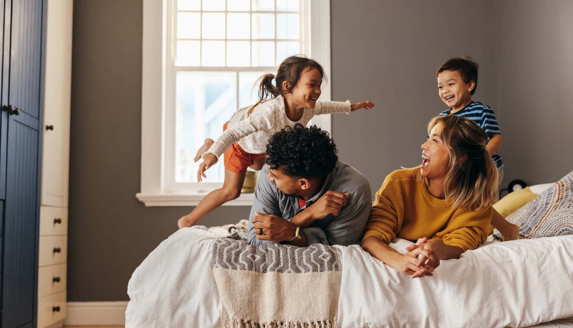 Family jumping on bed